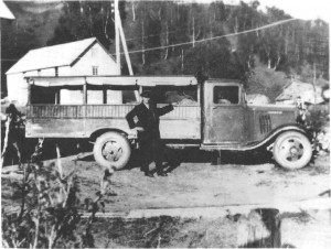 Den første lastebilen på Mosletta, Chevrolet modell 1935 var det Baro Krog­stad som eide. Her er den ny med påbygd platting og overbygg for rutekjø­ring, utført av Brudal smie. Bildet er tatt ved handelsmann Stokke.